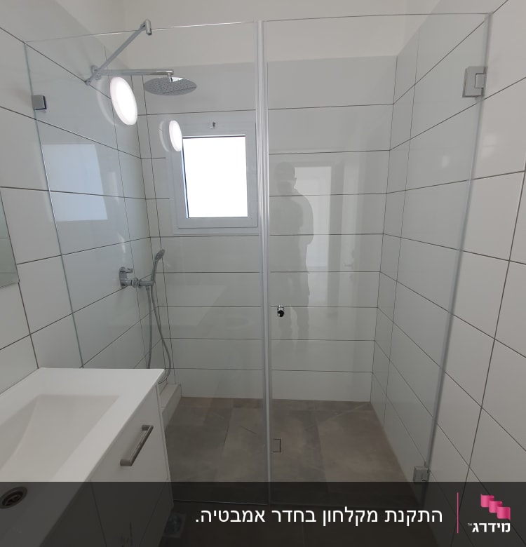 מקלחון זכוכית עם ראש מקלחת עגול וקירות לבנים